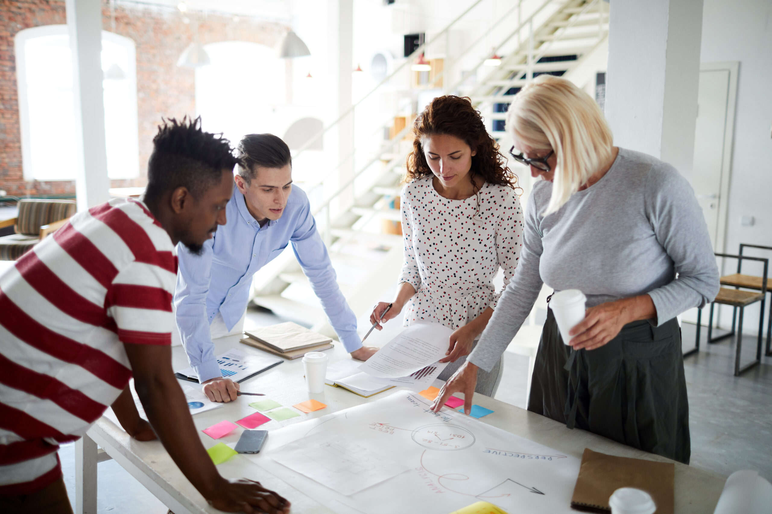Group of business team looking at business plan on the table and working with it at office