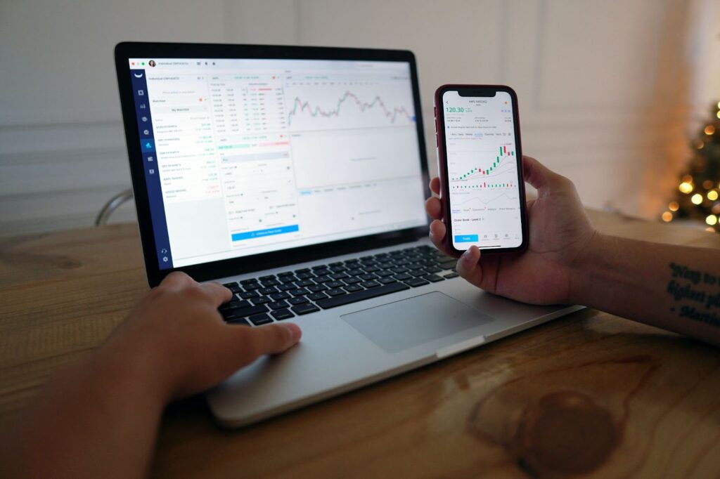 man monitoring his cashflow on his phone and computer