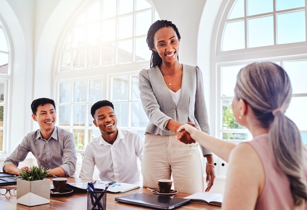 Newly onboarded employee shaking hands with new colleague
