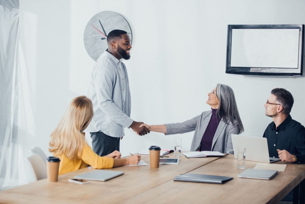 A man shaking hands with his manager after his exit interview