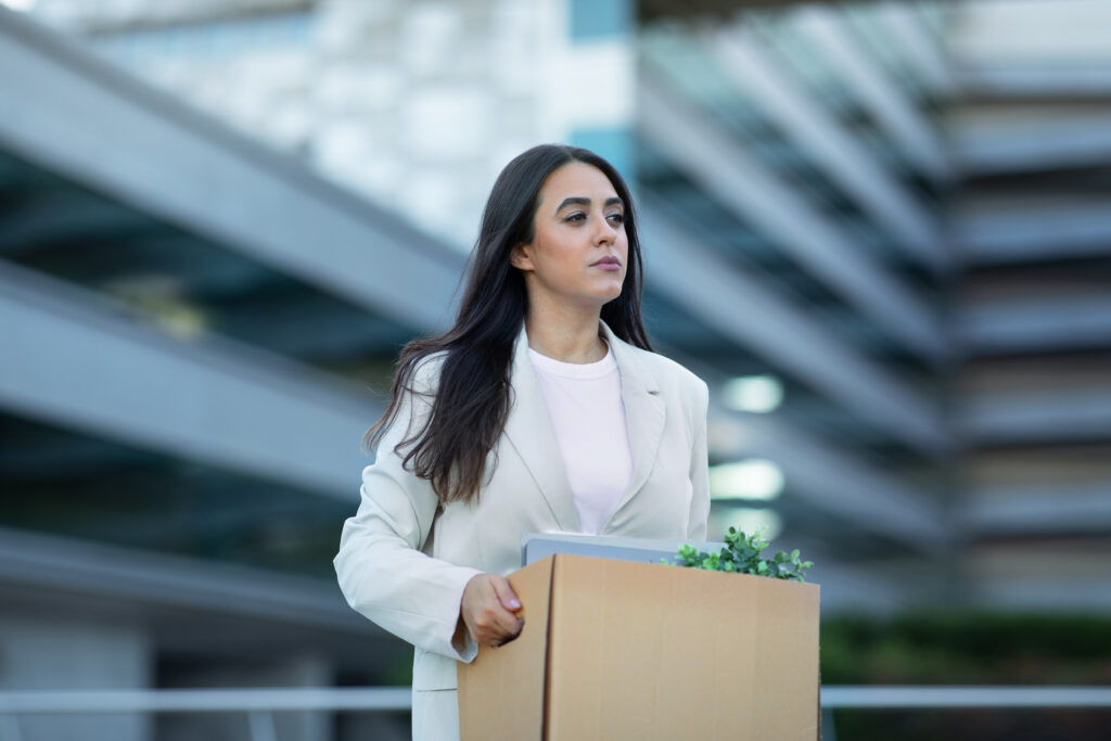 Woman leaving an office building carrying a box