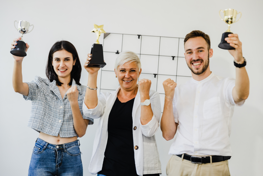 Employees holding up their trophies
